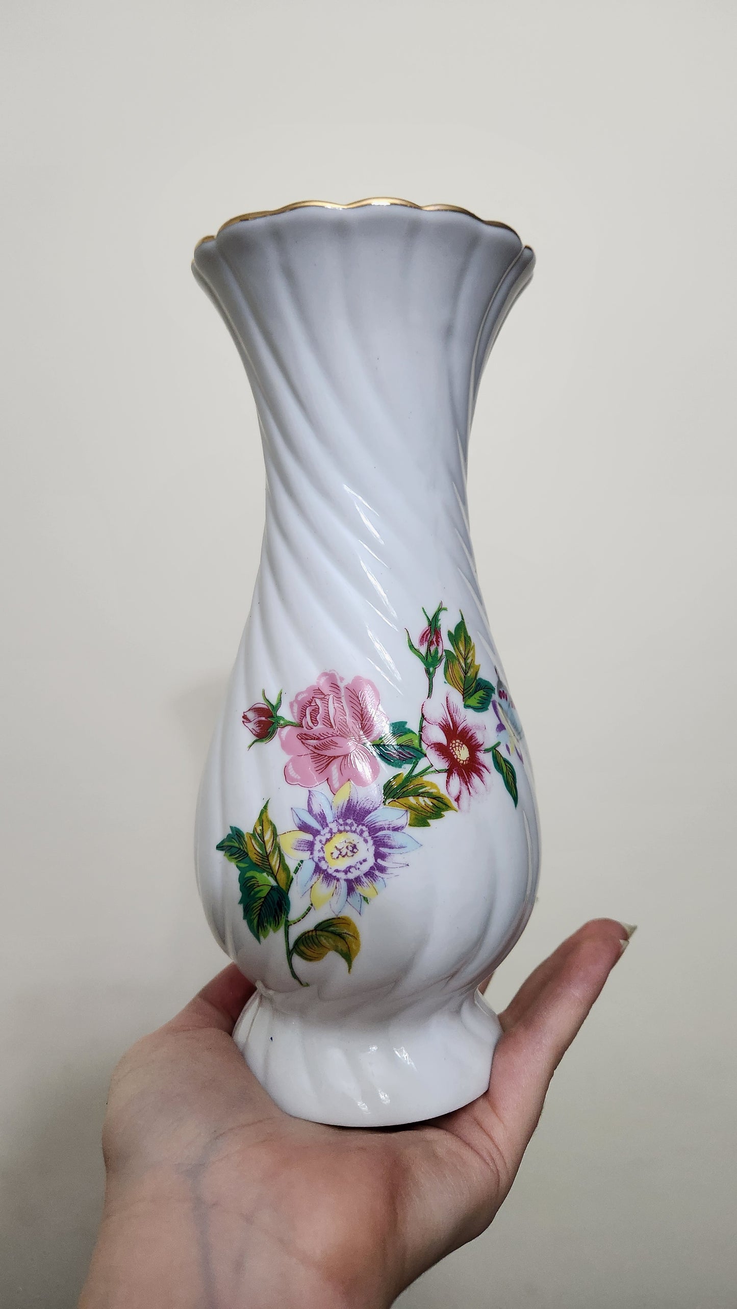 vintage porcelain vase with a floral design and a fluted spiral shape