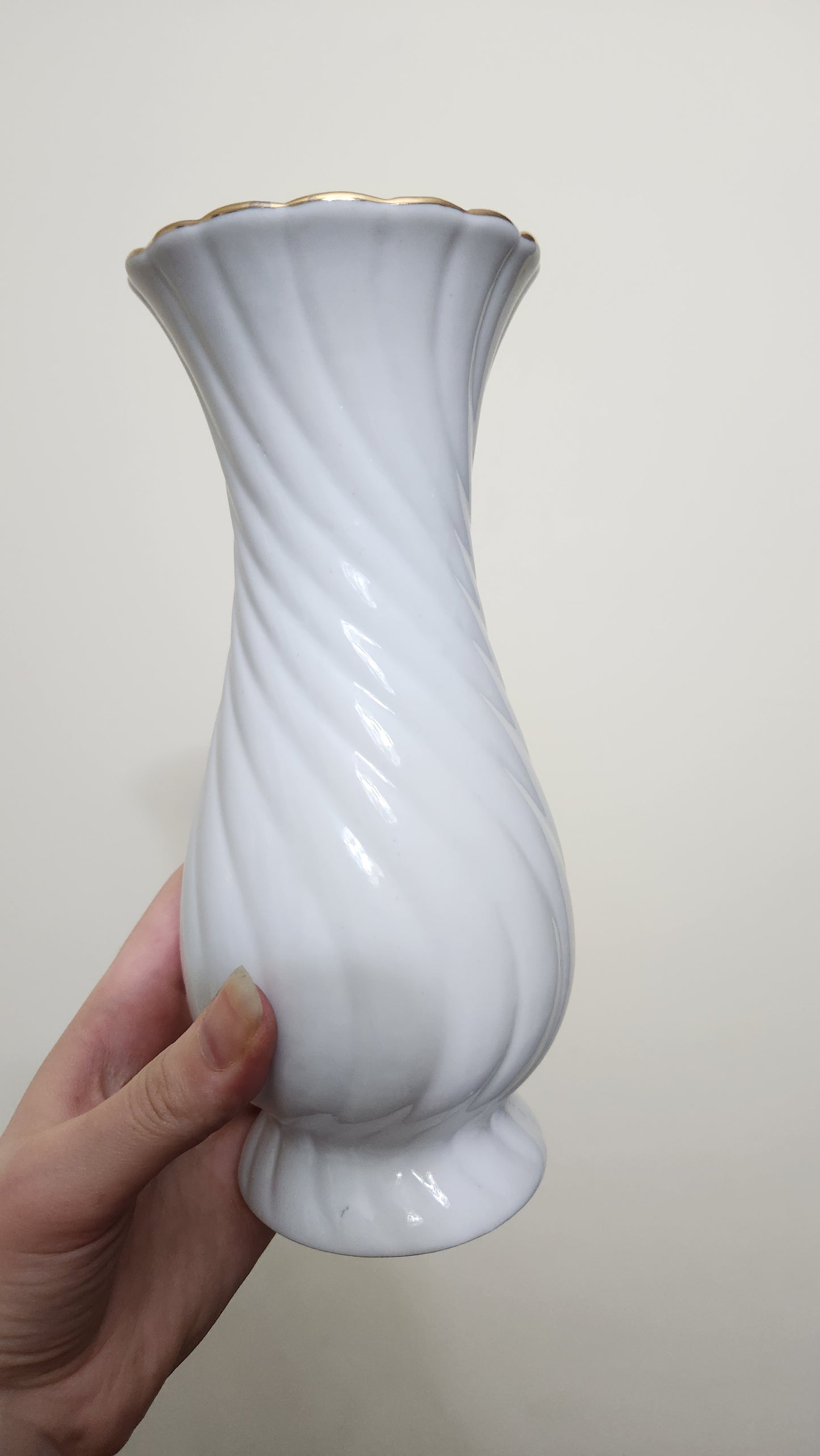 vintage porcelain vase with a floral design and a fluted spiral shape