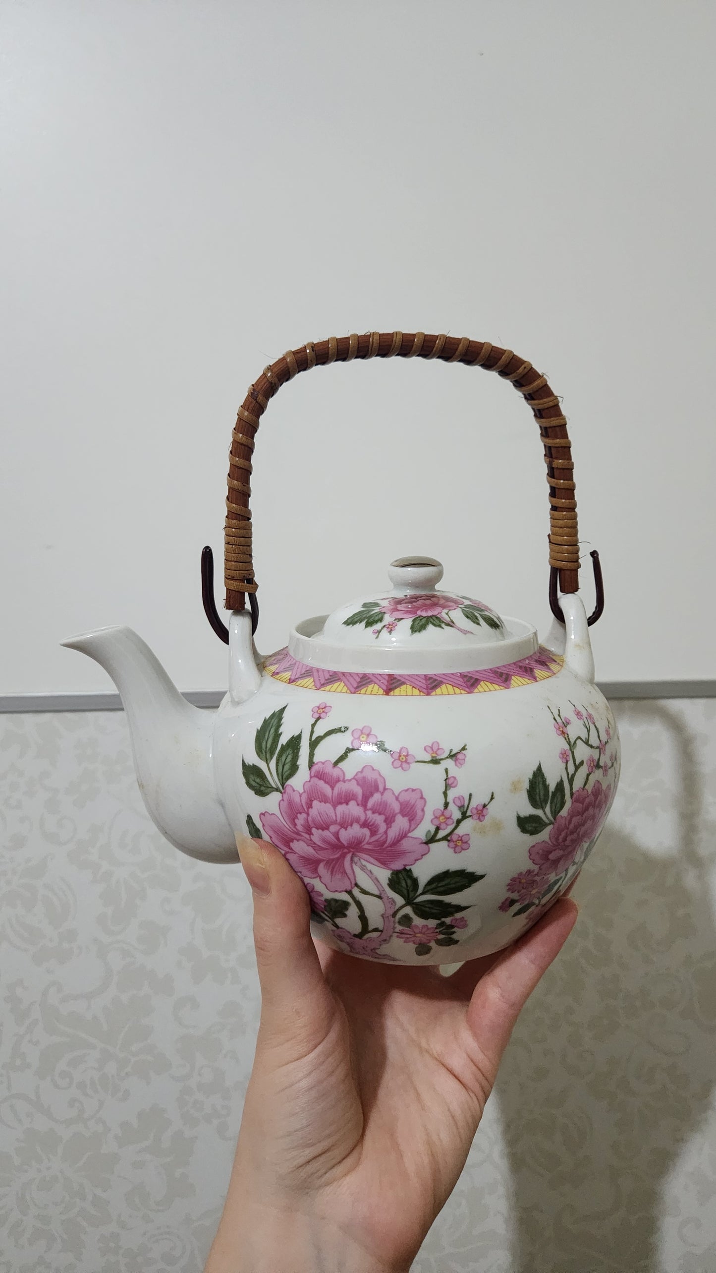 Mingei Japan porcelain teapot with a pink floral design and a rattan handle