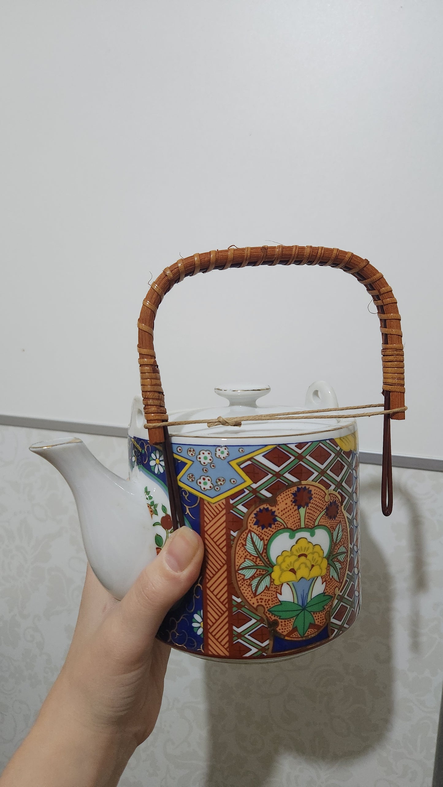 Vintage Japanese Imari ware porcelain teapot with a wicker handle